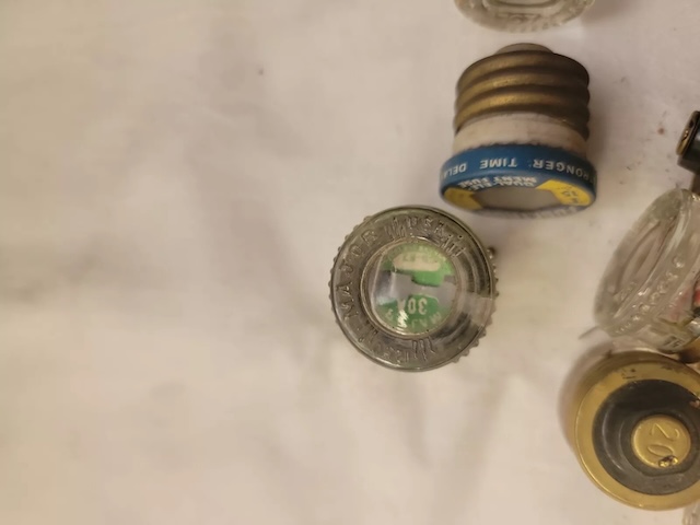 A closer look at different vintage glass fuses, revealing labels and markings that hint at their specific uses in electrical systems