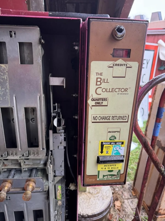 A close-up of the coin mechanism labeled “The Bill Collector,” which accepted quarters and dollar bills but offered no change—a true hallmark of mid-century vending innovation