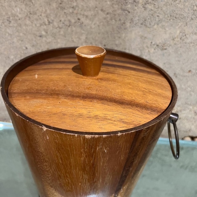 A beautifully preserved vintage ice bucket with a sleek wooden lid and a warm patina, a true relic of vintage entertaining