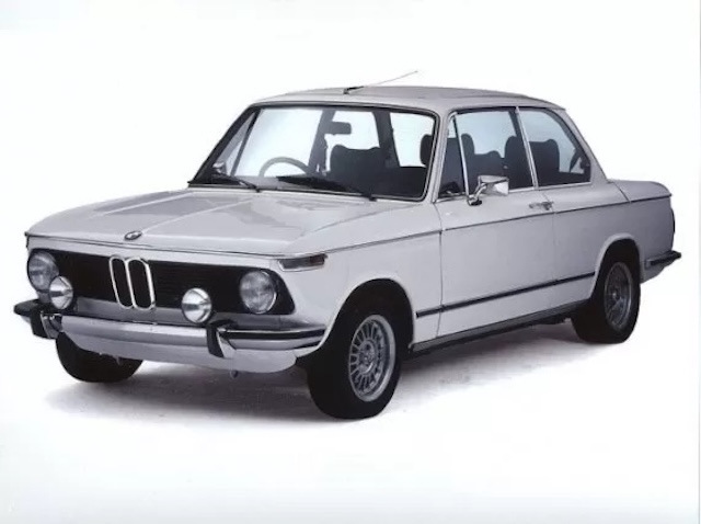 The BMW 2002 Tii in white, epitomizing its blend of stylish simplicity and robust performance, a key part of BMW's racing legacy in the 1970s