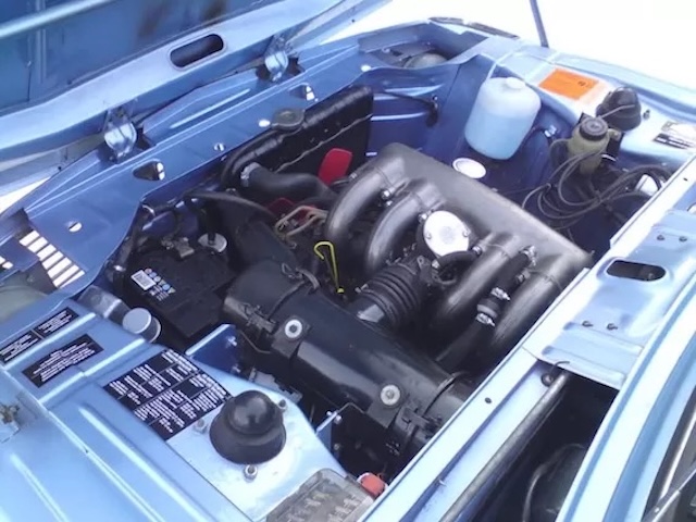 The engine bay of a BMW 2002 Tii reveals the power of the 2.0-liter, four-cylinder engine, crucial for the car’s success in both everyday driving and endurance racing