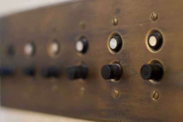 A close-up view of a row of push-button light switches, illustrating the uniformity and practicality of these switches in older buildings, often used in historic mansions