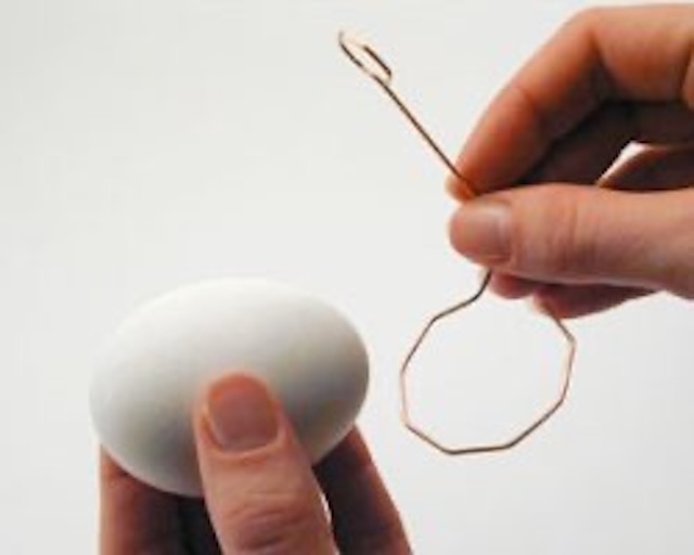 A demonstration of the egg dipper in use, illustrating its practicality during festive Easter egg dyeing sessions.