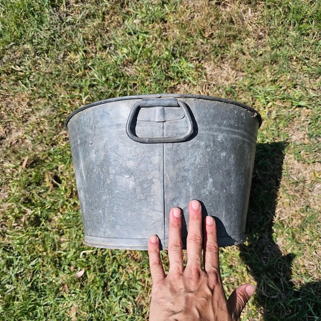 Held up to the sunlight, this vintage washtub shows off its textured surface and decades of reliable service