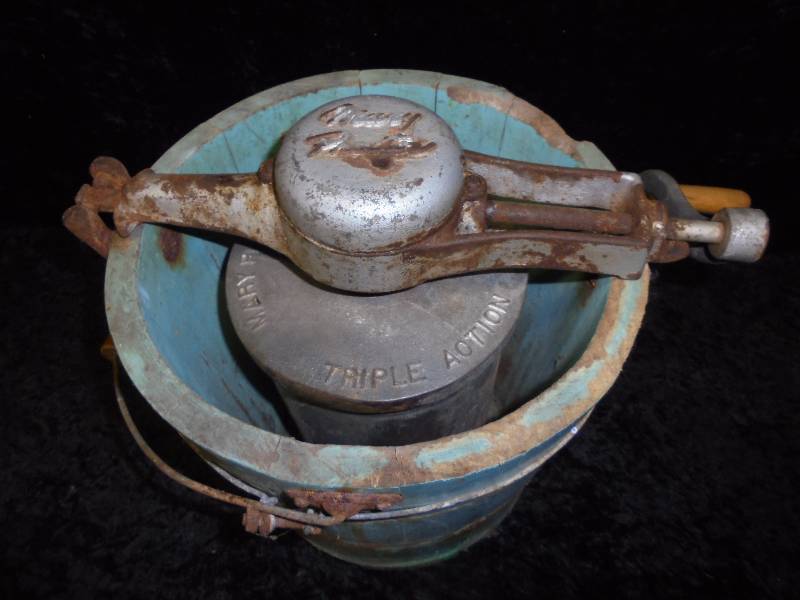 A close-up of the inner churn and "Triple Action" label of the Vintage Mary Proctor Ice Cream Maker, which highlights its innovation in achieving smooth, creamy ice cream