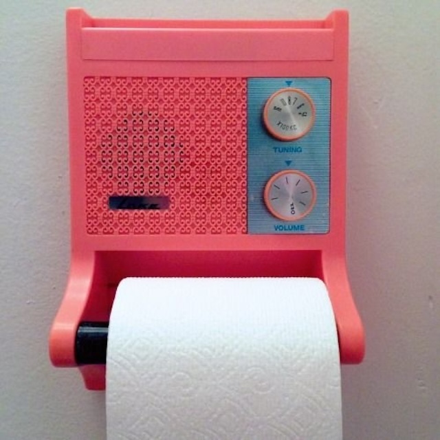 A vibrant pink retro restroom radio, complete with tuning and volume knobs, blending nostalgia with everyday practicality