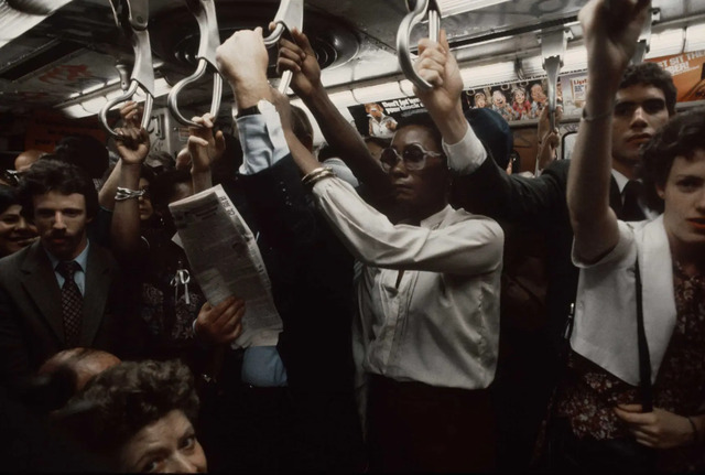 A crowded subway car during rush hour in 1981, with commuters packed together, each immersed in their own world as they ride through New York’s veins.