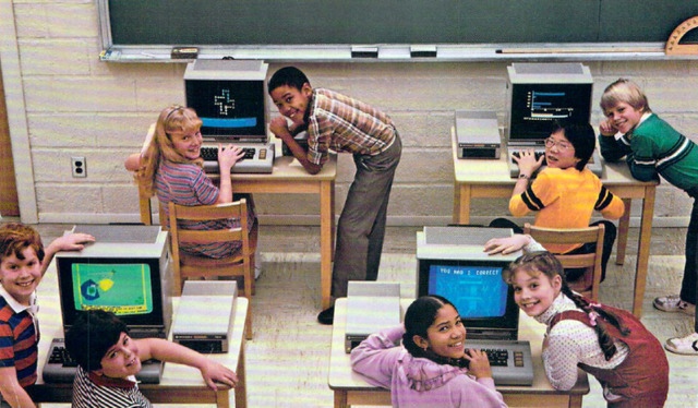 A group of children engaging with personal computers in a classroom, a glimpse into the growing influence of computers on youth education in the 1980s.