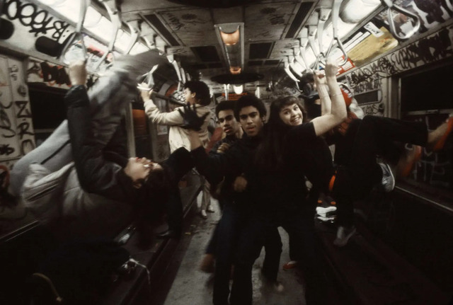 A group of rebellious teens strike a pose aboard the 6 train in the South Bronx, their vibrant energy adding to the pulse of the city in 1981.