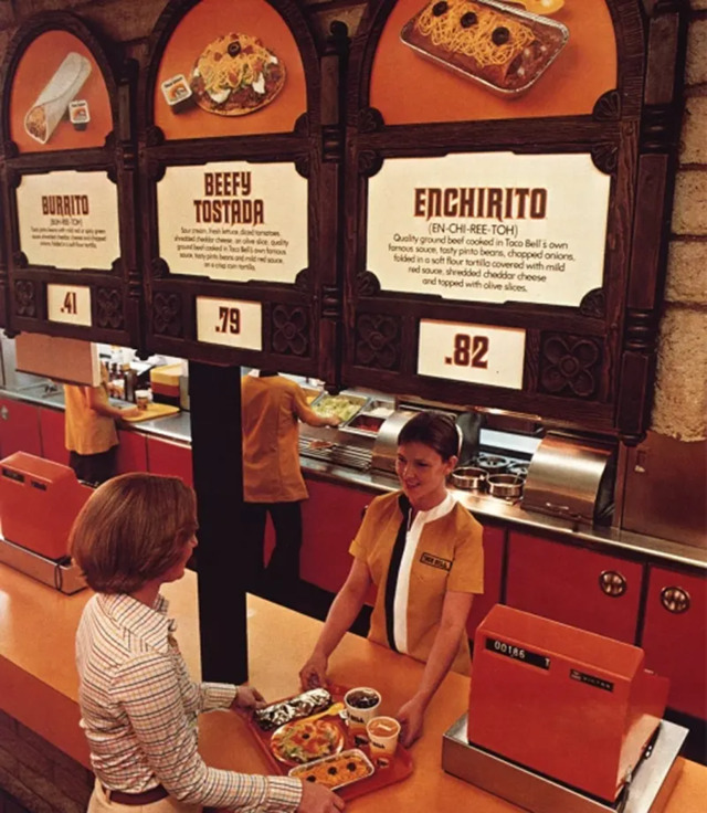 An image from the 1970s showcasing Taco Bell’s interior, with menu boards that list iconic items like Beefy Tostadas and Enchiritos. The affordable prices were a huge draw for customers at the time.