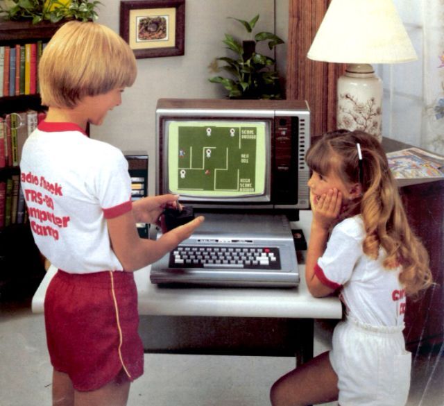 Children playing video games on an early personal computer