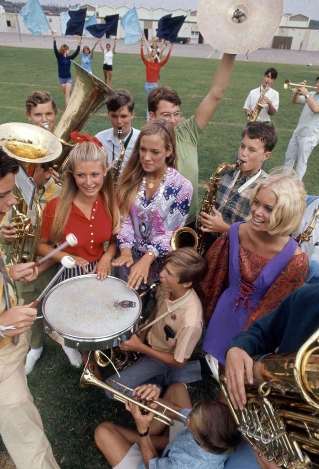 In a rare moment, a high school marching band and a trio of female students were captured together, each exuding their own take on '60s fashion.