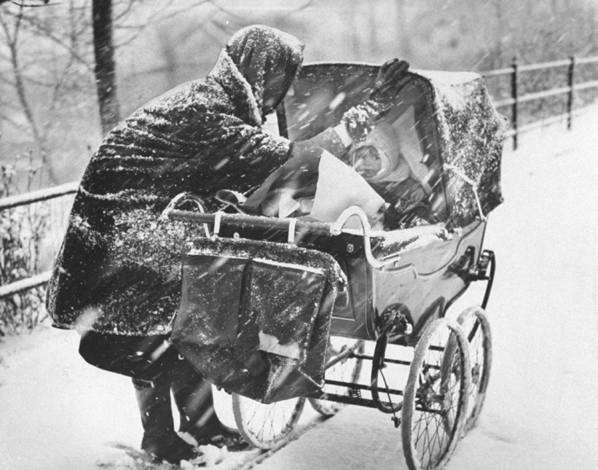 A devoted mother shields her baby from the biting snow as they brave Central Park’s winter chill, 1964.