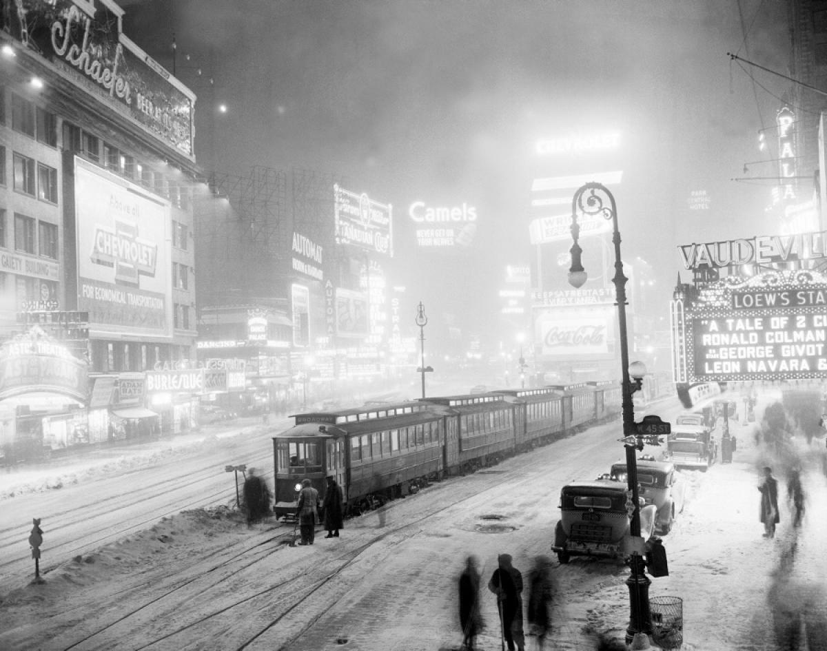 A surprise snowstorm leaves passengers stranded in Times Square after a frozen switch halts streetcars in their tracks, 1936.