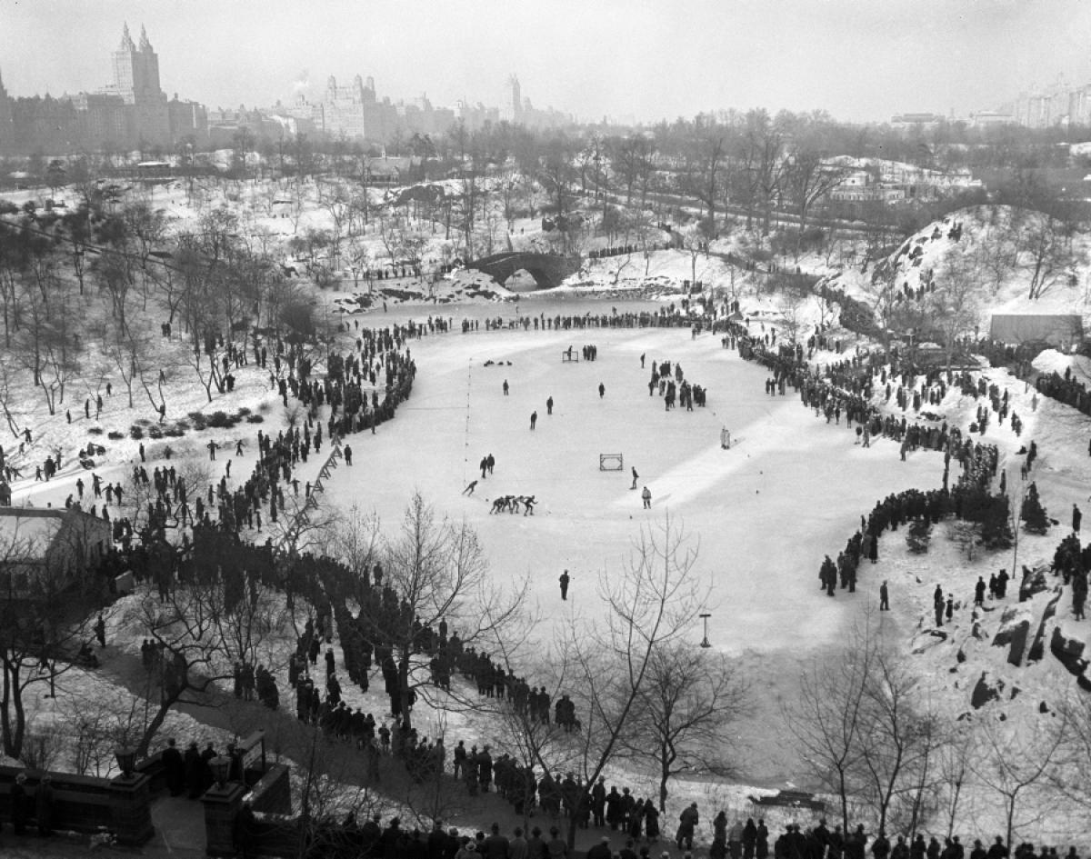 Bundled-up New Yorkers eagerly gather at the 59th Street lake in Central Park, ready to embrace the winter chill, 1936.