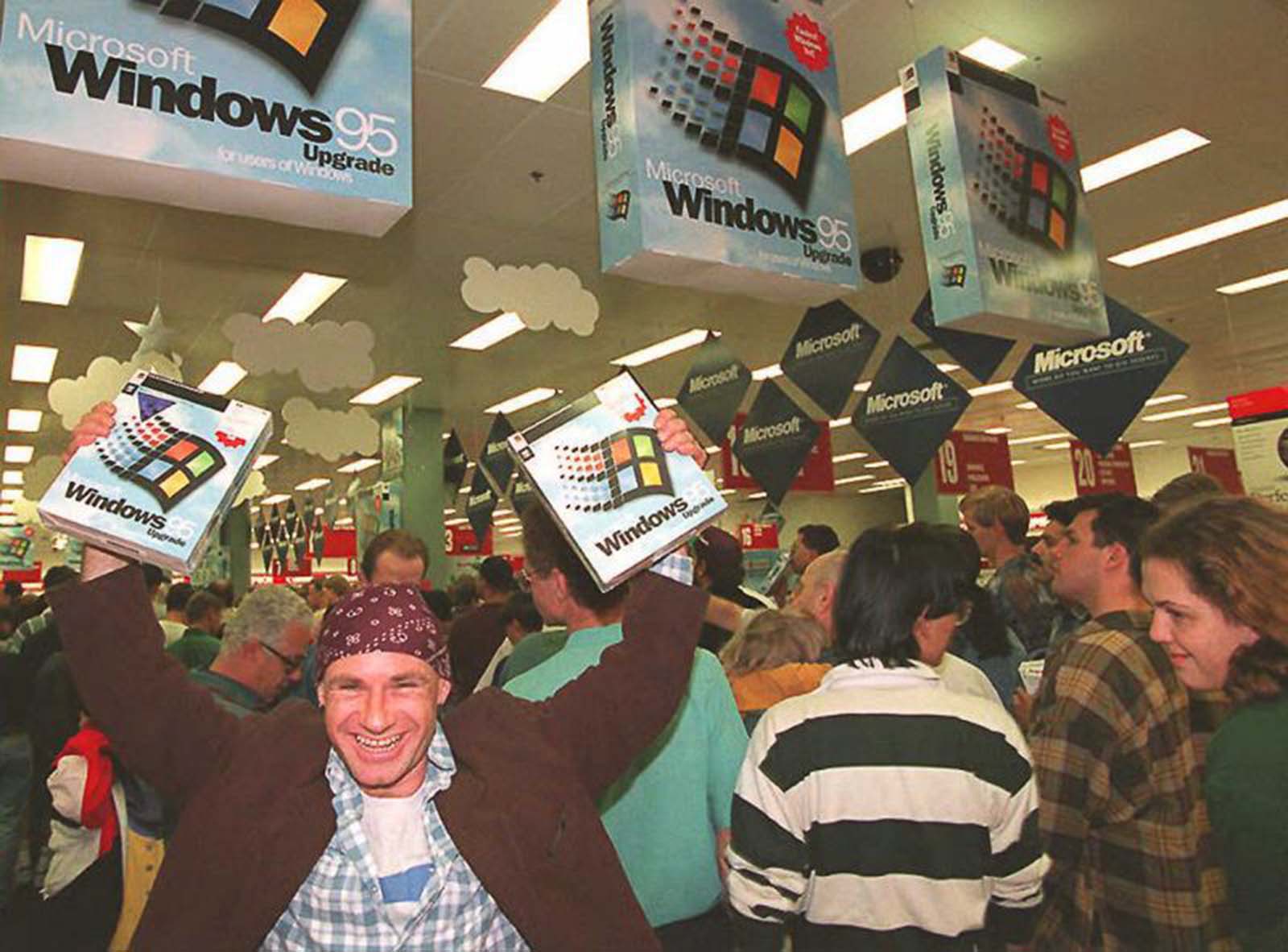 Mikol Furneaux proudly waves two copies of Windows 95 at a midnight launch event in Sydney, Australia.