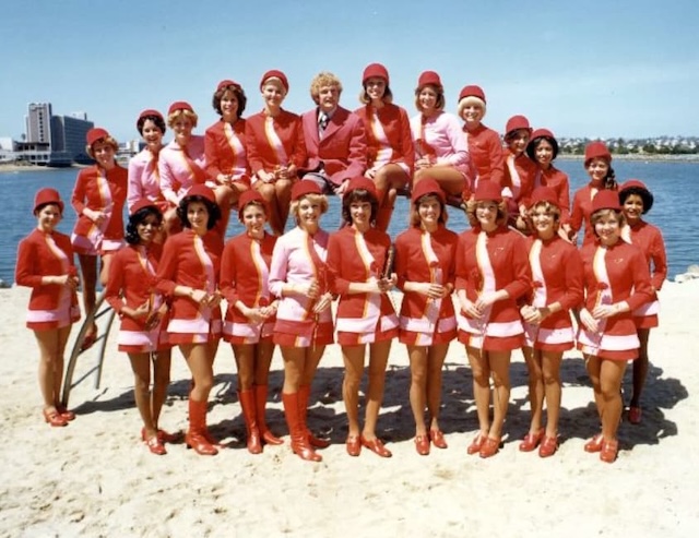 A group of flight attendants enjoys a sunny day at the beach, relaxing and having fun together