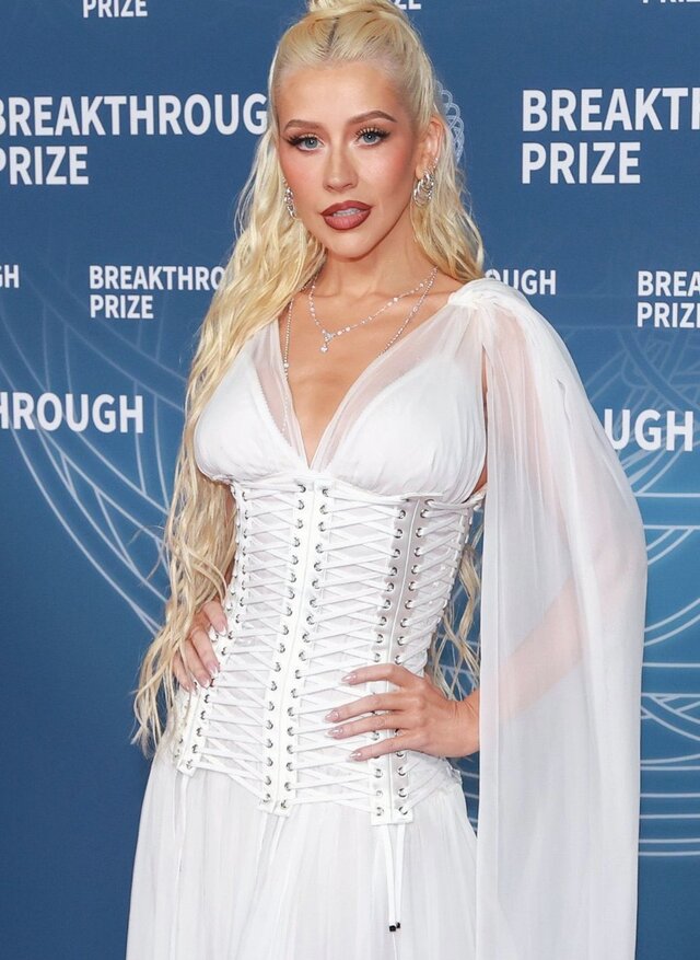 Her white chiffon dress, featuring a plunging neckline and semisheer cape sleeves, highlighted her radiant skin and confident presence.