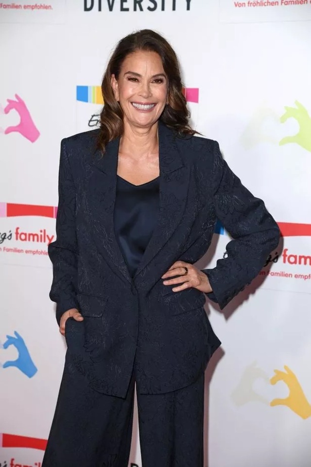 Teri Hatcher appeared at the Ernsting’s Family Fashion Show, dressed in a floral-patterned navy suit paired with a low-cut blouse and dark heels