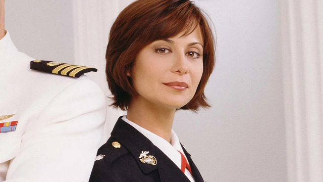 Catherine Bell appears in her Marine Corps uniform as Lt. Col. Sarah “Mac” MacKenzie, capturing the strength and authority that made her character unforgettable in JAG.