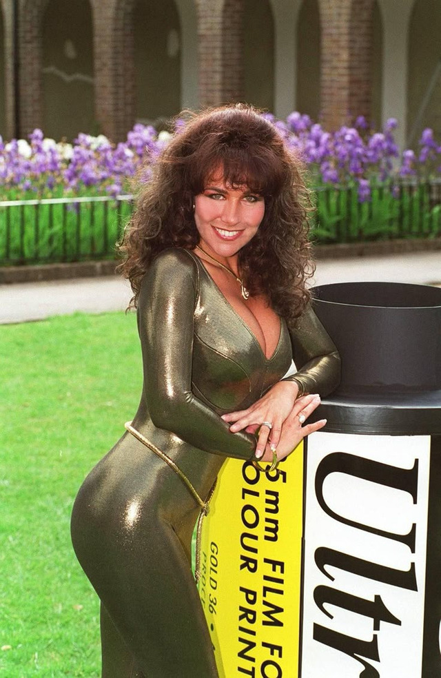 The model in a metallic catsuit, posing next to an oversized film roll — an iconic shot of her era.