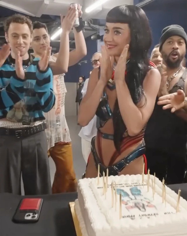 Captured by an anonymous crew member, the footage shows Katy Perry standing in front of a table holding a white birthday cake with lit candles