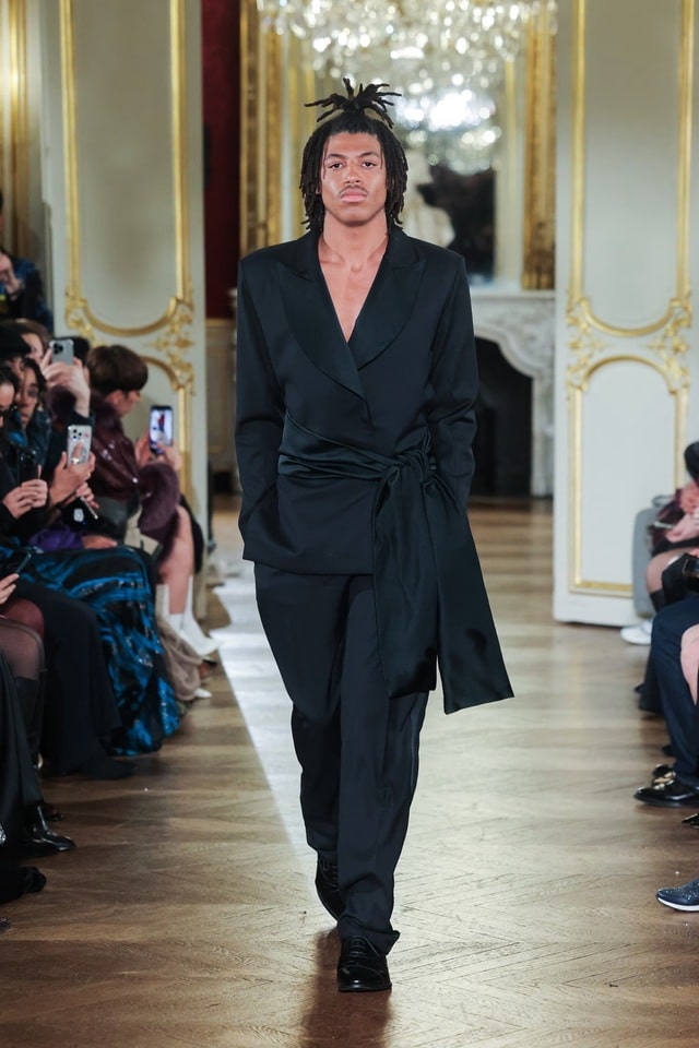 Clad in an all-black suit with a dramatic cutout detail on the back, he effortlessly captivated the audience with his poise and striking presence