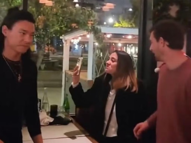 A tense moment as the intoxicated woman films the confrontation, displaying her displeasure.