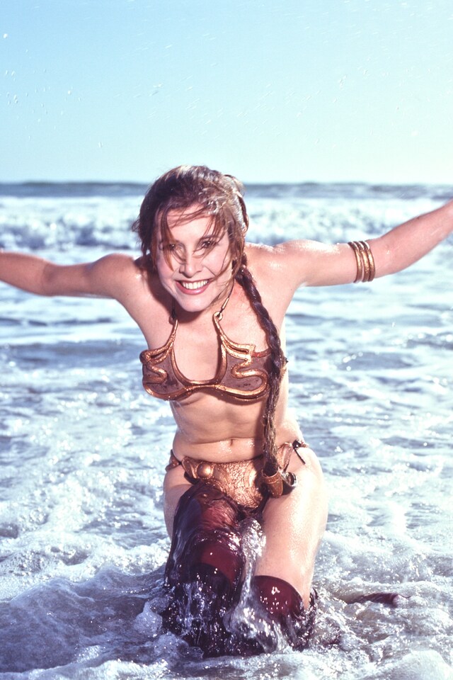 Carrie Fisher laughing in the iconic slave Leia bikini scene from Return of the Jedi.